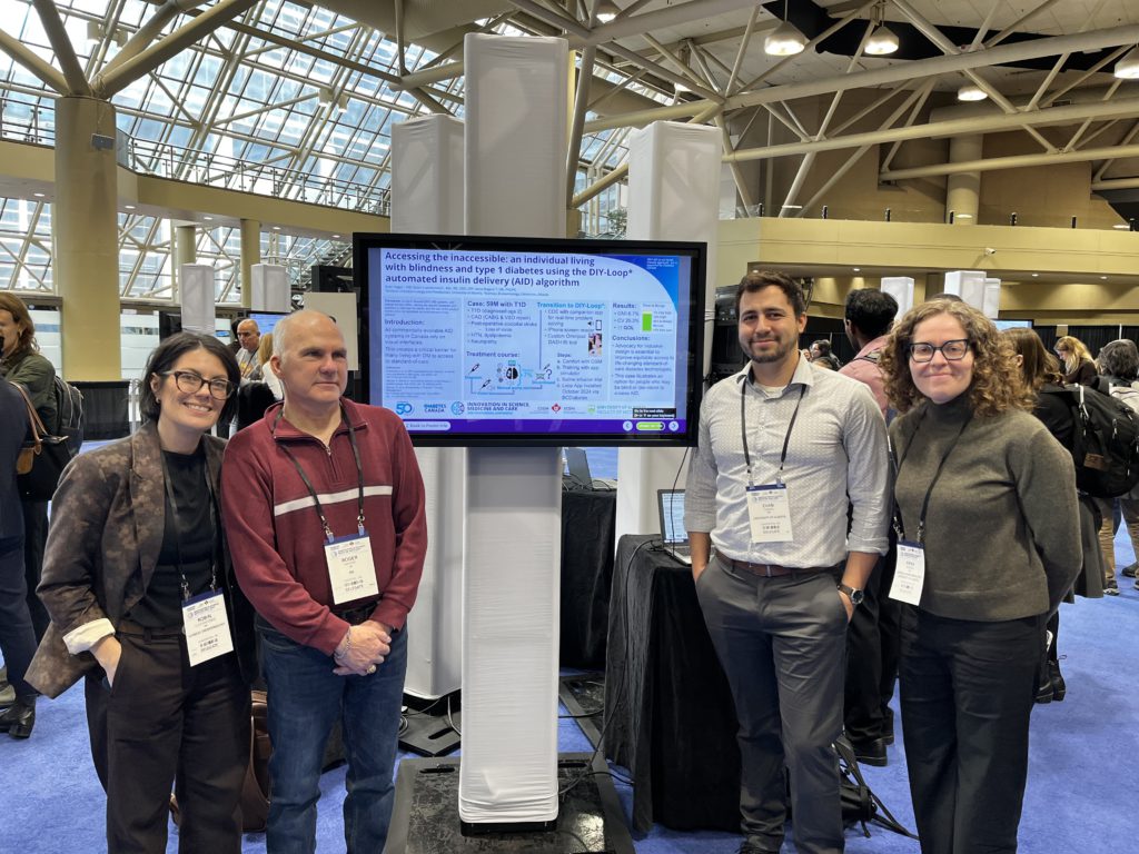Robin, Roger, and their clinical team standing beside their conference poster on accessible AID for a person who is blind